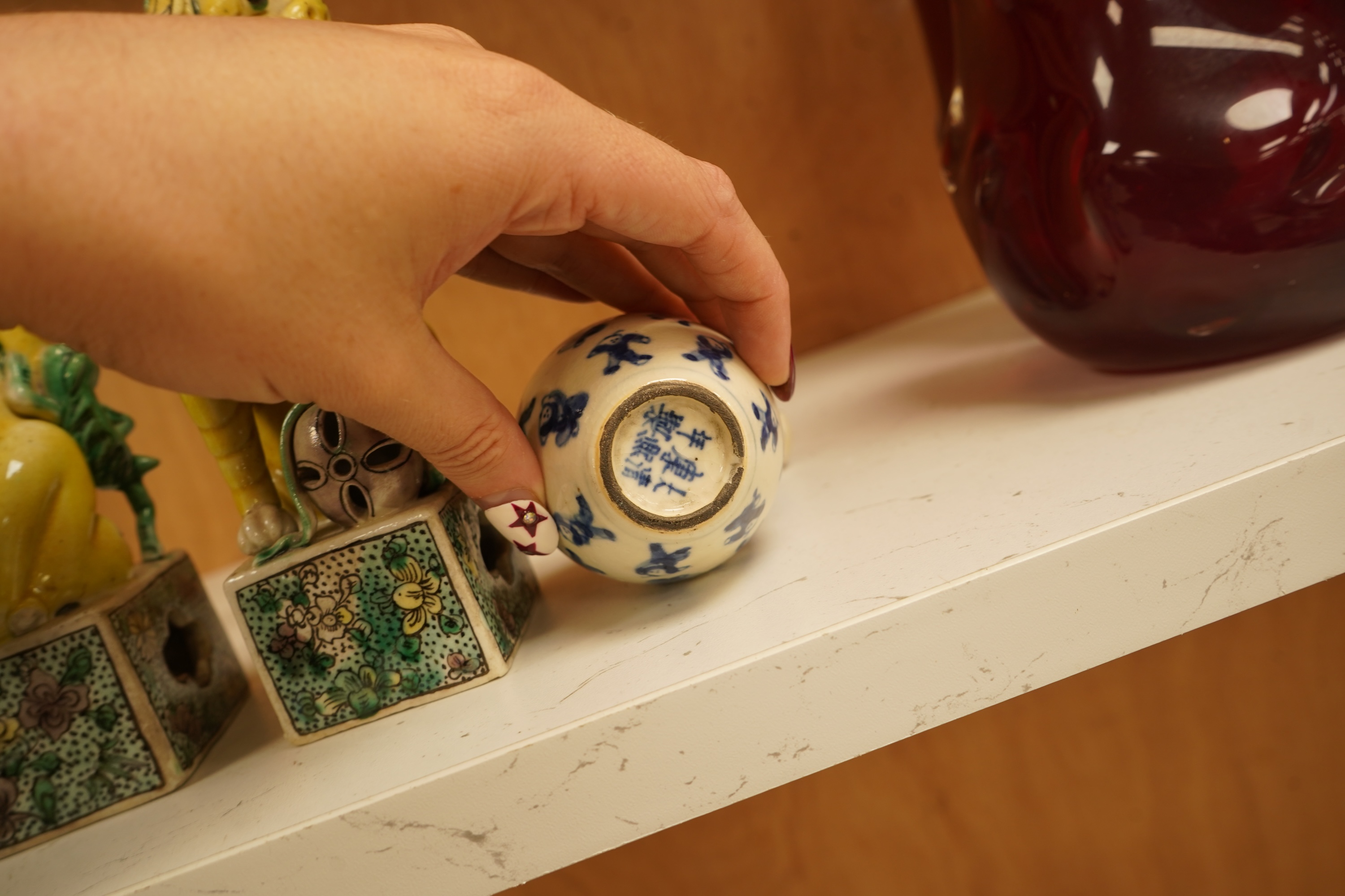 A pair of late 19th/early 20th century Chinese famille verte lion dogs and a similar pair of blue and white miniature ‘boys’ jars and covers, 15cm